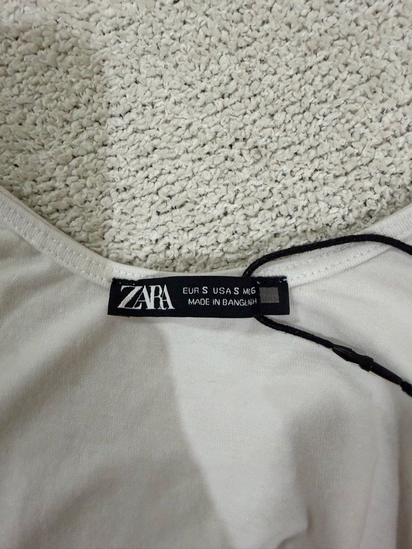 Zara White Bodysuit S (Category: Sleeveless) located in Subic. Submitted by kittysclosetsale (Listing ID 1465093405, Image 3). Description: - Brand: Zara - Style: Sleeveless scoop neck bodysuit with snap bottom closure - Material: Comfortable ribbed cotton - Condition: Brand new with tags (BNWT) - Size: Small (fits true to size) - Perfect as an everyday basic layering piece.