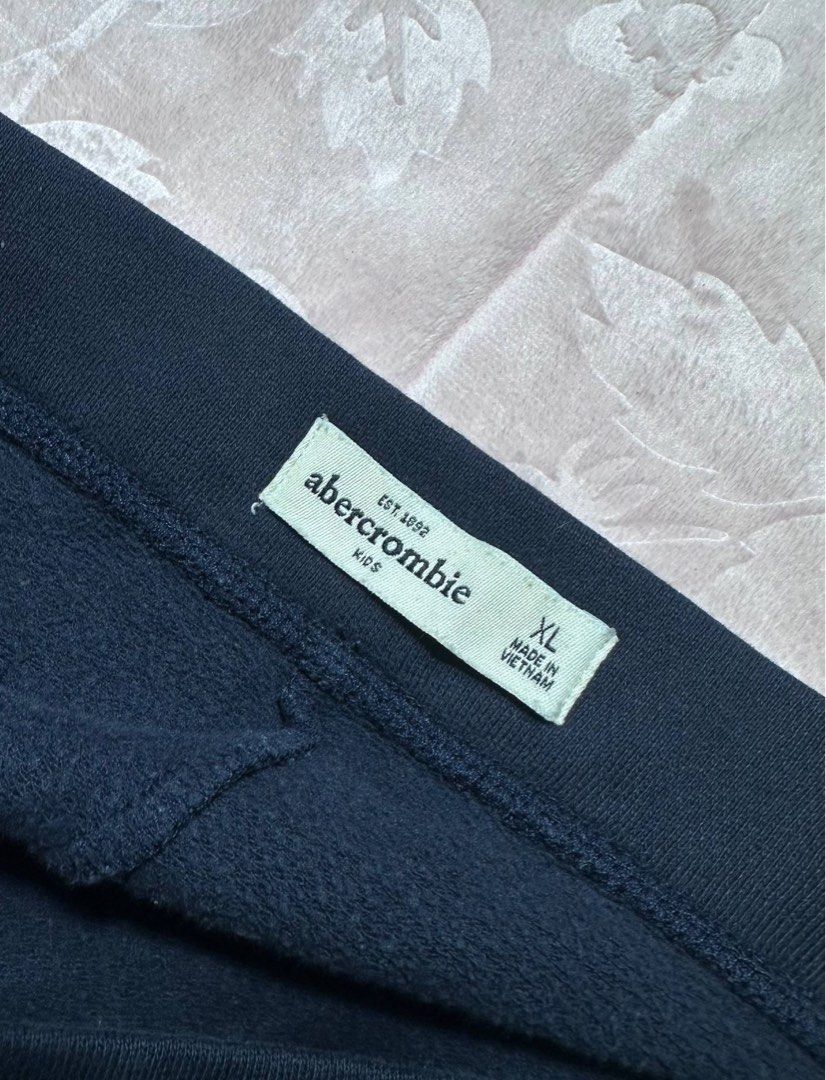 ABERCROMBIE Navy Blue Sweatpants (Category: Other Bottoms) located in San Fernando. Submitted by rianne_von (Listing ID 1459592464, Image 3). Description: Size XL on tag W: 14.3 in L: 28 in info: ✧ navy blue sweatpants w/ embroidered “a&fitch est 92” varsity-style detailing ✧ drawstring waistband w/ a slim straight-leg silhouette ✧ very good thrifted condition; repaired hole present with minor signs of wear ✧ color may vary slightly due to lighti