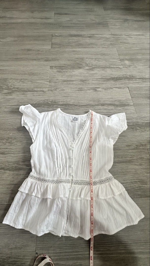 ANNA Clothing White V-Neck Blouse (Category: Blouses) located in Quezon City. Submitted by gracejongin88 (Listing ID 1459545240, Image 3). Description: ANNA Clothing white short-sleeve blouse. V-neck with lace trim, button-up front, and ruffled hem with lace. Lightweight and perfect for warm weather. Worn 2x only. Bought inVietnam Fits S to semi-medium. Cotton fabric Rfs: di na kasya sakin.