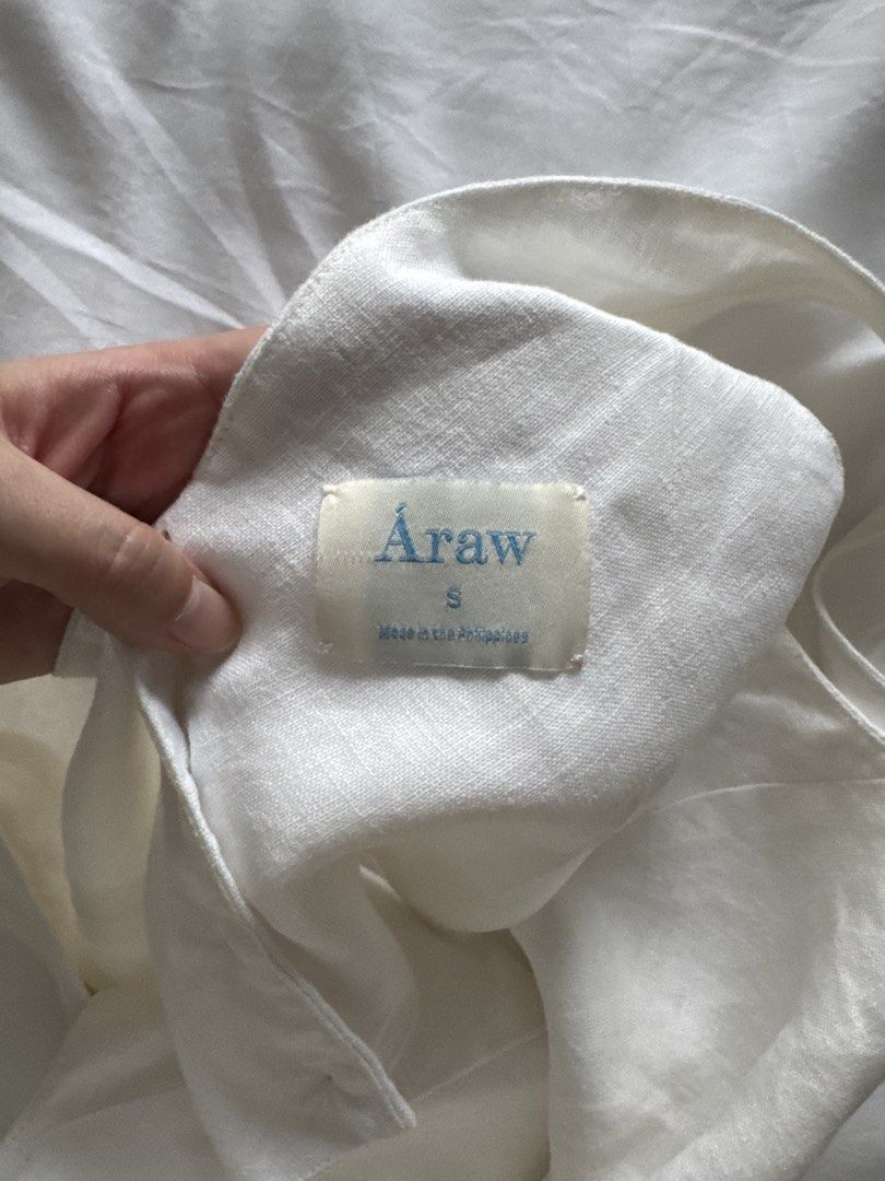 Araw The Line White Cropped Top (Category: Sleeveless) located in Makati City. Submitted by sabmi (Listing ID 1459566704, Image 3). Description: - White linen crop top - Brand: Araw - V-neckline - Button details down the front - Pure linen - Made in the Philippines Measurements (laid flat): Width: 15.5” Length (from shoulder): 14.5”.