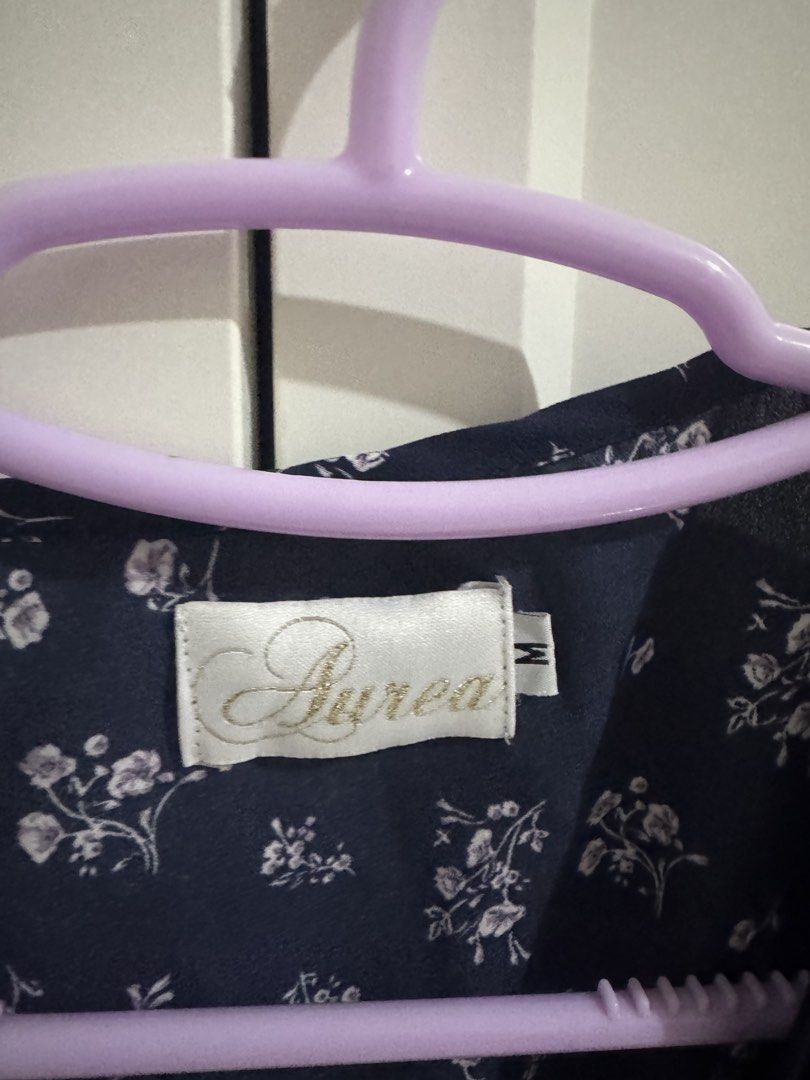 Aurea Navy Floral Wrap Top Size M (Category: Blouses) located in Mangatarem. Submitted by jvleexx (Listing ID 1459626321, Image 2). Description: - Navy blue top with a charming white floral print. - Flattering wrap style with a convenient side tie closure. - Features short sleeves with a delicate ruffle detail at the hem. - Made from a lightweight fabric, ideal for comfortable, casual outings. - Versatile piece that can be dressed up or down..