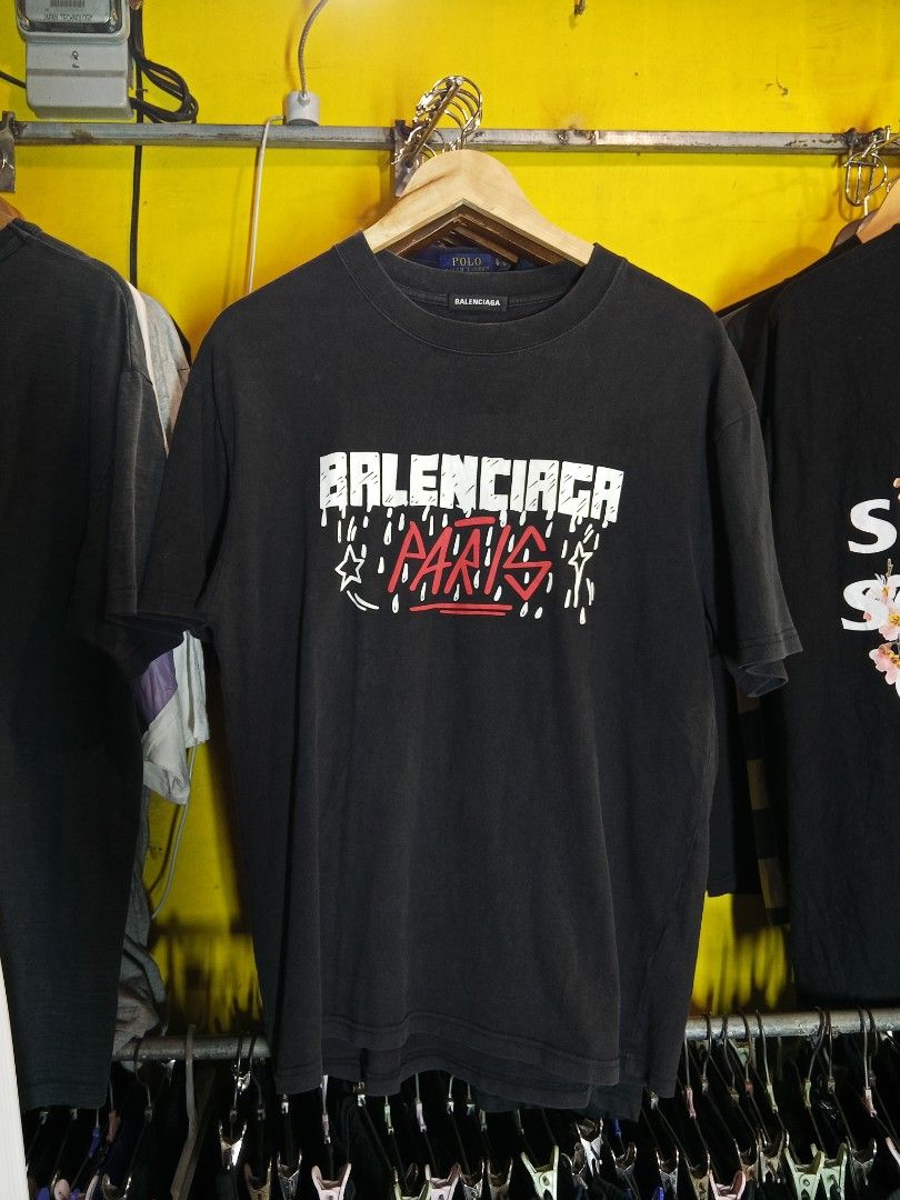 Balenciaga Paris T-shirt (Category: Tshirts & Polo Shirts ) located in Lucban. Submitted by aeronroyyy (Listing ID 1459556554, Image 1). Description: - Authentic Balenciaga Paris graphic t-shirt - Features iconic Balenciaga logo with 'Paris' text - Estimated size S (please check tag and photos for fit) - Made from soft, comfortable cotton - Ideal for everyday casual wear - Detailed design visible in provided photos.