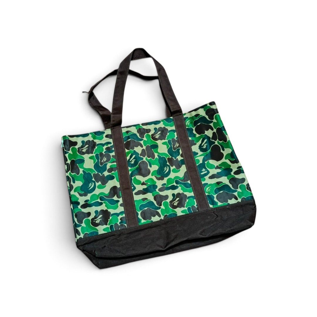 BAPE Camo Tote Bag Green (Category: Luxury Bags & Wallets) located in Manila. Submitted by southstreethub.ph (Listing ID 1459582833, Image 1). Description: - BAPE green camouflage pattern - Condition: Very Good Conditio - Dimention: 19 Width 14 Lenght - Durable canvas material - Two comfortable top handles - Spacious interior for all your essentials - Ideal for everyday use or as a fashion statement - Price: 999 Plus Shipping fee.