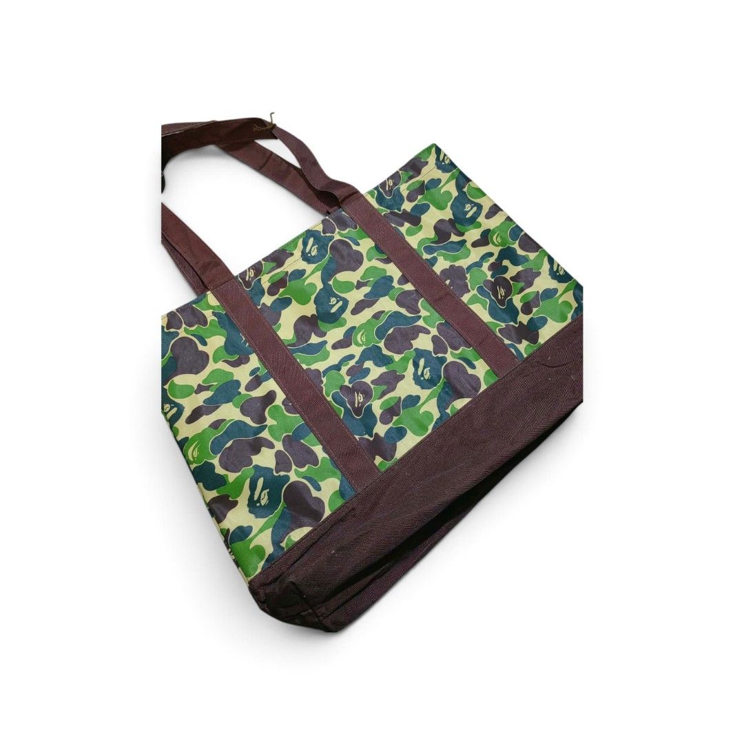 BAPE Camo Tote Bag Green (Category: Luxury Bags & Wallets) located in Manila. Submitted by southstreethub.ph (Listing ID 1459582833, Image 2). Description: - BAPE green camouflage pattern - Condition: Very Good Conditio - Dimention: 19 Width 14 Lenght - Durable canvas material - Two comfortable top handles - Spacious interior for all your essentials - Ideal for everyday use or as a fashion statement - Price: 999 Plus Shipping fee.