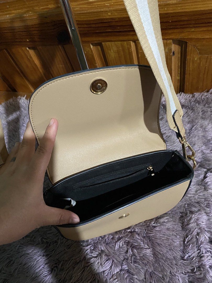 Beige Crossbody Bag with Striped Strap (Category: Cross-body Bags) located in La Trinidad. Submitted by kinleyky (Listing ID 1459617911, Image 2). Description: - Cute beige crossbody bag - Curved flap closure with magnetic snap - Main compartment and interior zippered pocket - Adjustable strap with stylish beige and white stripe pattern - Gold hardware details - Ideal for everyday use.