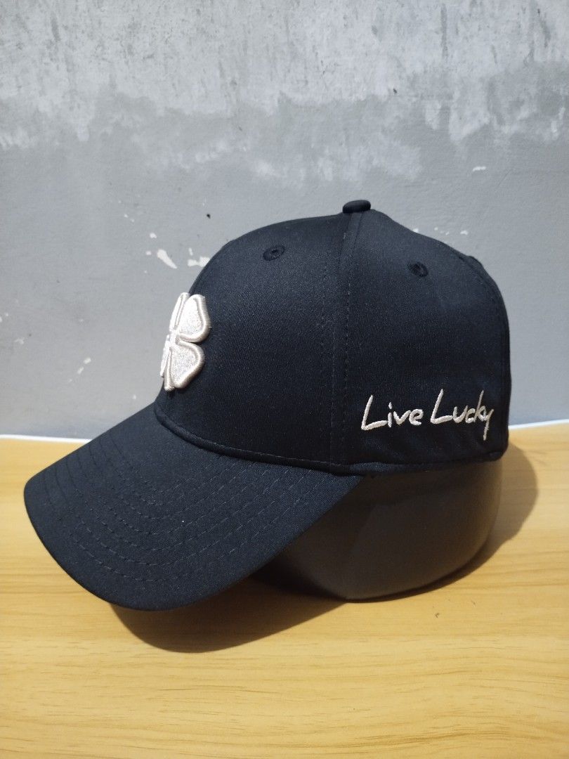 Black Clover Live Lucky Fitted Golf Cap (Category: Caps & Hats) located in Angeles City. Submitted by thehustlersculture (Listing ID 1459602412, Image 2). Description: - Brand: Black Clover - Type: Baseball Cap - Design: Signature clover logo on front - Embroidery: "Live Lucky" on the side - Back Detail: "BLACK CLOVER" and "blackcloverusa.com" tag - Fit: Adjustable strap for a comfortable fit - Occasion: Ideal for casual wear.