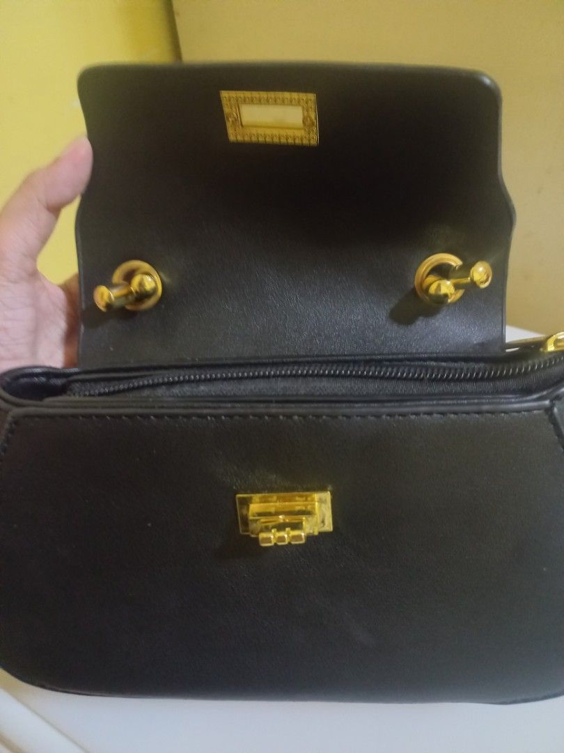 Black Handbag with Gold Clasp and Chain Strap (Category: Cross-body Bags) located in Manila. Submitted by mrose_2412 (Listing ID 1459583969, Image 2). Description: ⭐️Brand: Parisian ⭐️ Condition: Brand New (Never used) ⭐️ Color: Classic Black with Gold-tone Hardware Design Features: ⭐️ Curved structured silhouette with a top flap ⭐️ Twist-lock front accent closure ⭐️ Top handle with knot accent for hand-carrying .