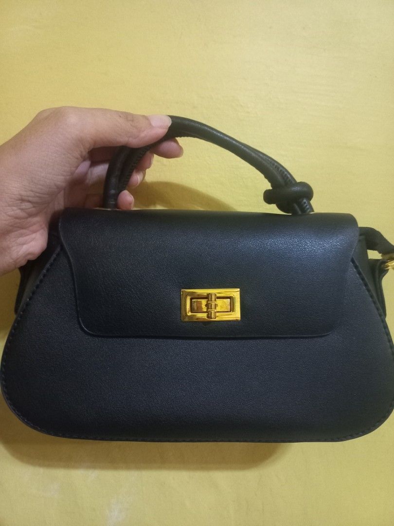 Black Handbag with Gold Clasp and Chain Strap (Category: Cross-body Bags) located in Manila. Submitted by mrose_2412 (Listing ID 1459583969, Image 1). Description: ⭐️Brand: Parisian ⭐️ Condition: Brand New (Never used) ⭐️ Color: Classic Black with Gold-tone Hardware Design Features: ⭐️ Curved structured silhouette with a top flap ⭐️ Twist-lock front accent closure ⭐️ Top handle with knot accent for hand-carrying .