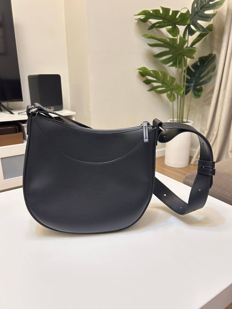 Black Pebbled Vegan Leather Crescent Shoulder Bag (Category: Shoulder Bags) located in Manila. Submitted by softlysorted (Listing ID 1459626142, Image 2). Description: Minimalist black shoulder bag with a curved hobo-style silhouette—easy to pair with casual, office, or everyday outfits. • Textured pebbled leather-like exterior • Wide shoulder strap • Secure top-zip closure • Silver-tone hardware • Fully lined interior • Spacious enough for every