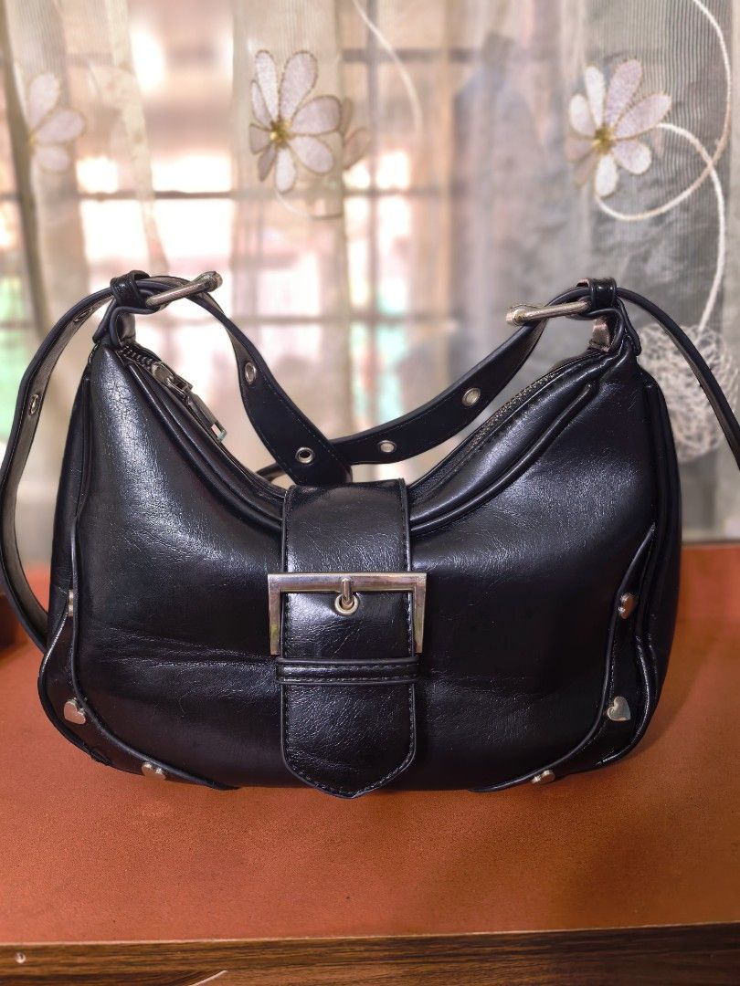 Black Shoulder Bag with Silver Buckle and Heart Studs (Category: Shoulder Bags) located in Manila. Submitted by mysticfox.9b1678 (Listing ID 1459670260, Image 1). Description: - Cute black shoulder bag - Features a silver buckle on the front flap - Adorned with little heart studs along the bottom edge - Secure zipper closure at the top - Adjustable strap for comfortable wear - Ideal for everyday use.
