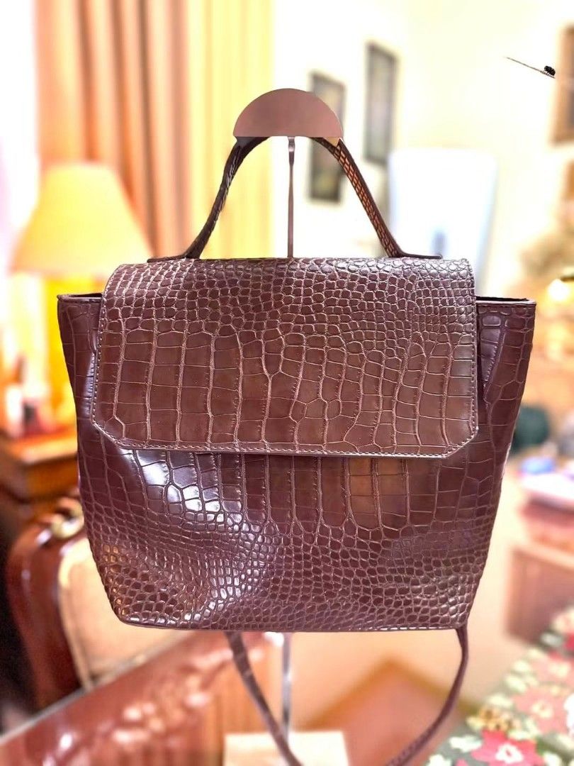 Brown Croc Embossed Handbag (Category: Cross-body Bags) located in Santo Domingo. Submitted by krizzies_korner (Listing ID 1459575220, Image 1). Description: - Stylish brown handbag with a luxurious croc-embossed texture. - Features a convenient top handle and a secure flap closure. - Comes with a detachable shoulder strap for versatile carrying options. - Ideal for both everyday errands and dressing up for events. - Spacious interior to hold all