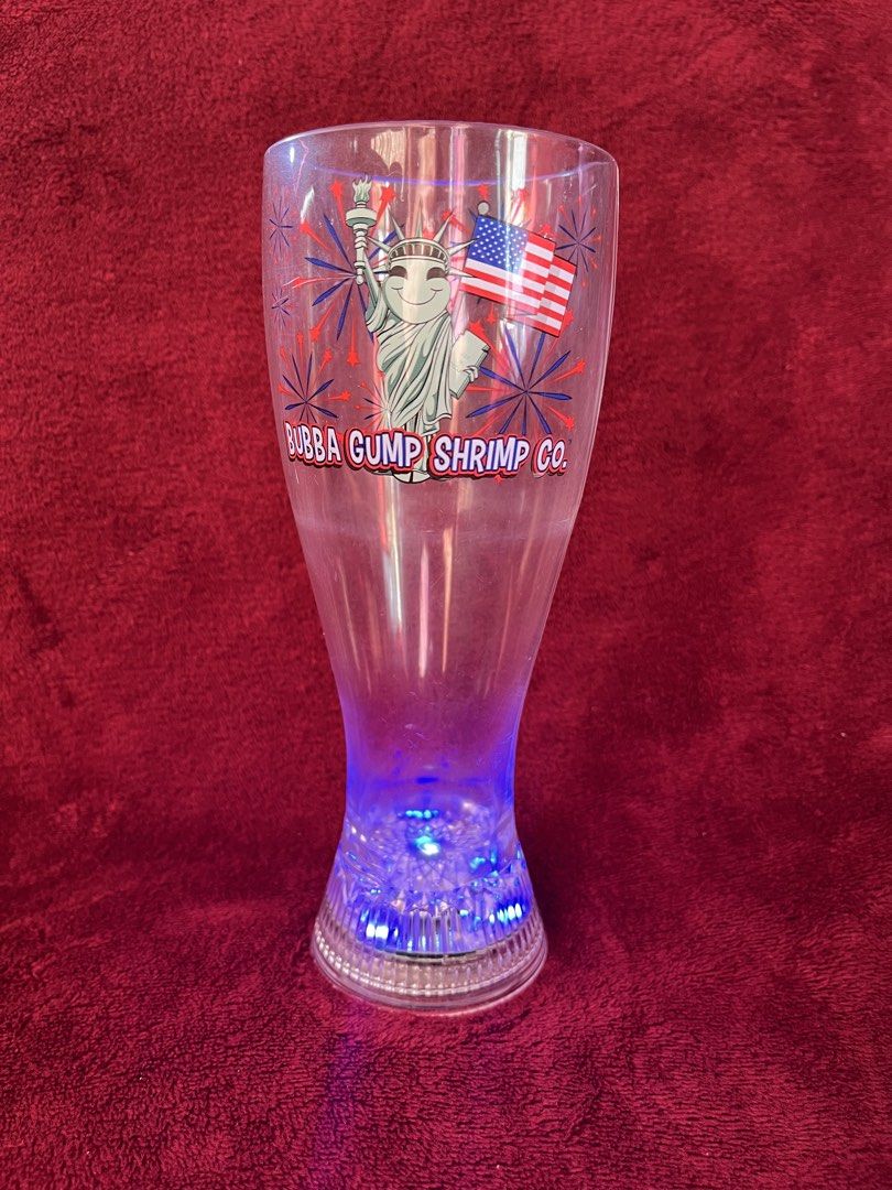 Bubba Gump Shrimp Co. Light-Up Plastic Glasses Set (Category: Other Home Decor) located in La Trinidad. Submitted by whatnotcollections (Listing ID 1459600304, Image 3). Description: - Set of 2 clear plastic glasses from Bubba Gump Shrimp Co. - Features Statue of Liberty graphic with American flags and fireworks. - Bases light up with LEDs: red, green & blue. The other cup only lights up red. -The glasses are approximately 7-5/8 inches tall and m