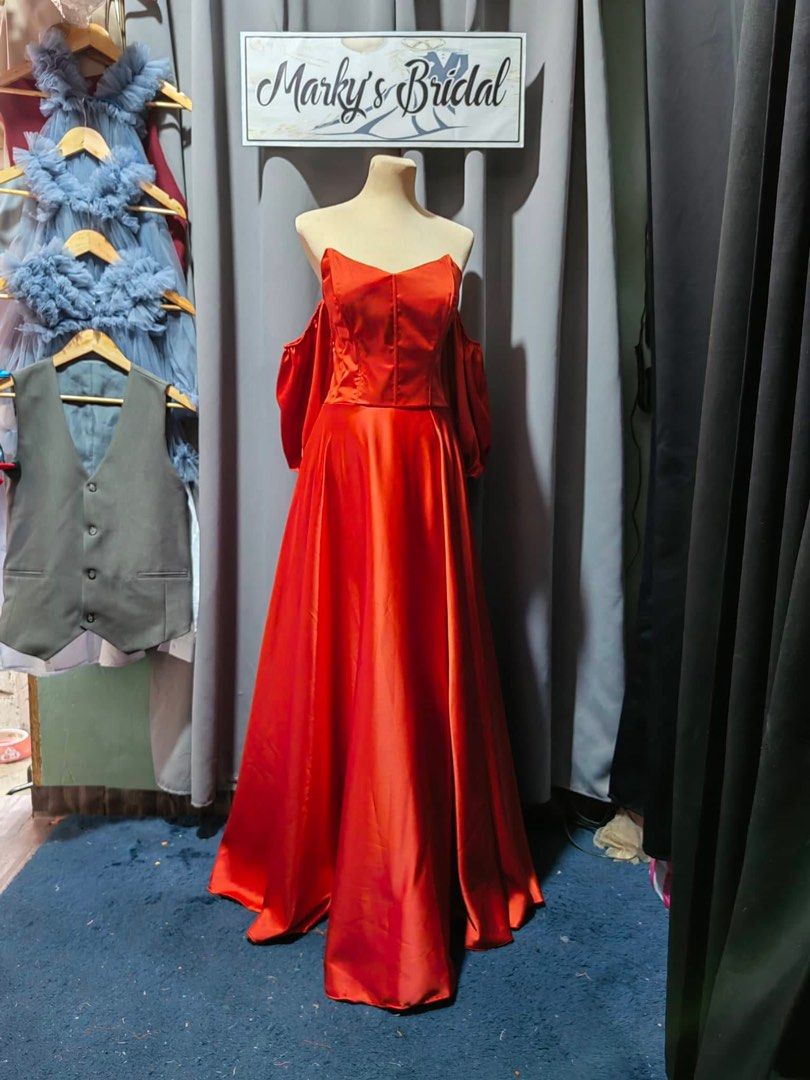 Burnt Orange Satin Off-Shoulder Evening Gown (Category: Evening dresses & gowns) located in Makati City. Submitted by nicsberry (Listing ID 1459672160, Image 2). Description: - Beautiful red satin gown - Off-shoulder design with puff sleeves - Corset-style bodice with lace-up back - Full A-line skirt - Ideal for formal events or as a bridesmaid dress -Adjustable fits L-XL - Has flaw on bone but can be repaired see photo.