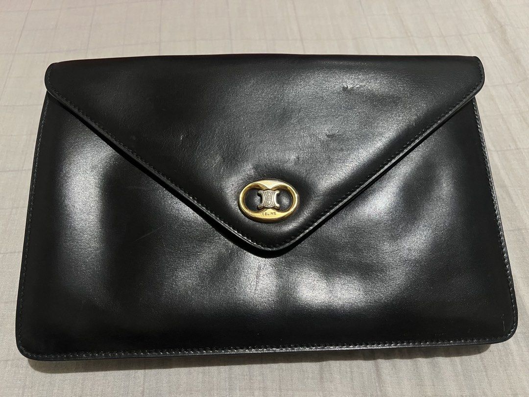 Celine Black Leather Envelope Clutch Bag with Triomphe Logo (Category: Luxury Bags & Wallets) located in Dagupan City. Submitted by casadebayongph (Listing ID 1459533582, Image 2). Description: - Classic Celine black leather envelope clutch - Iconic gold Triomphe logo hardware - Ideal for evening wear or as a statement piece - Minor signs of wear on leather, consistent with use. Hole on side for sling slot. - Clean interior - Timeless accessory.