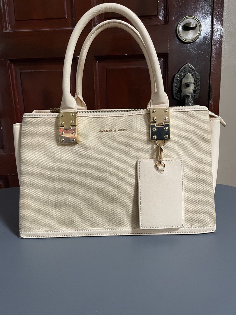 Charles & Keith Cream Canvas Top Handle Bag (Category: Luxury Bags & Wallets) located in Las Pinas. Submitted by gabriel0123 (Listing ID 1459647101, Image 1). Description: - Cream canvas handbag - Genuine leather trim - Elegant gold hardware details - Secure top zip closure - Multiple interior compartments for organization - Includes a small matching tag - Need cleaning - Ideal for everyday use.
