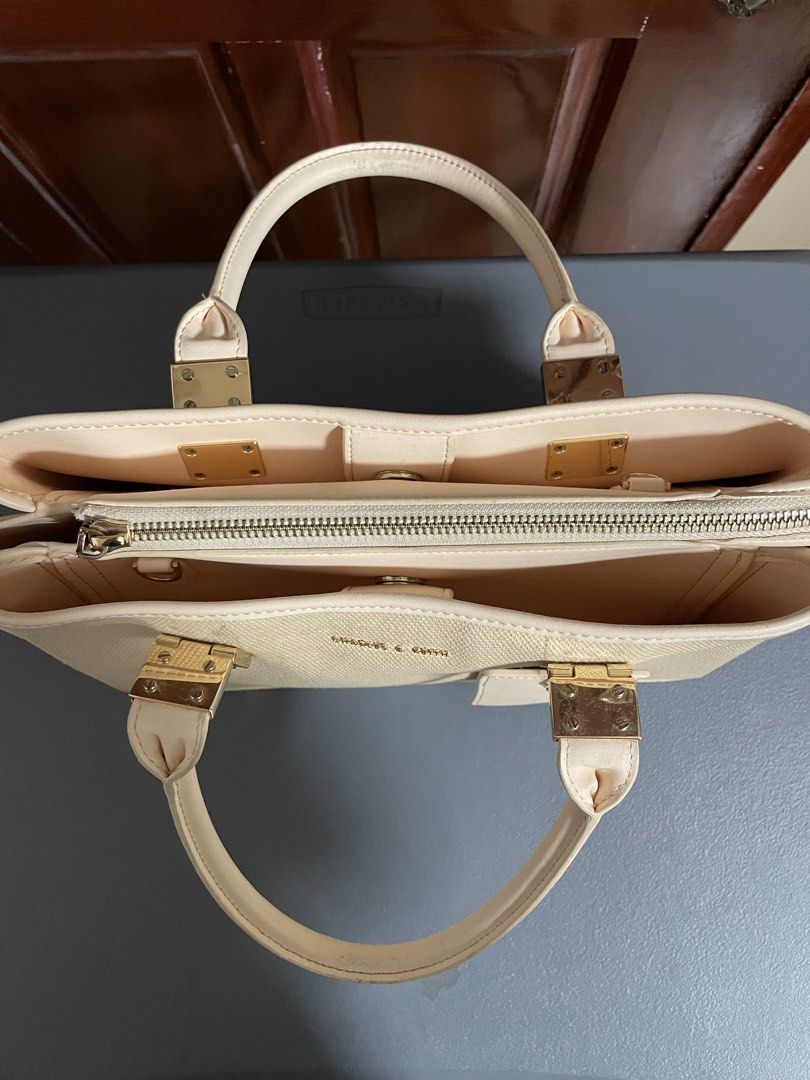 Charles & Keith Cream Canvas Top Handle Bag (Category: Luxury Bags & Wallets) located in Las Pinas. Submitted by gabriel0123 (Listing ID 1459647101, Image 2). Description: - Cream canvas handbag - Genuine leather trim - Elegant gold hardware details - Secure top zip closure - Multiple interior compartments for organization - Includes a small matching tag - Need cleaning - Ideal for everyday use.