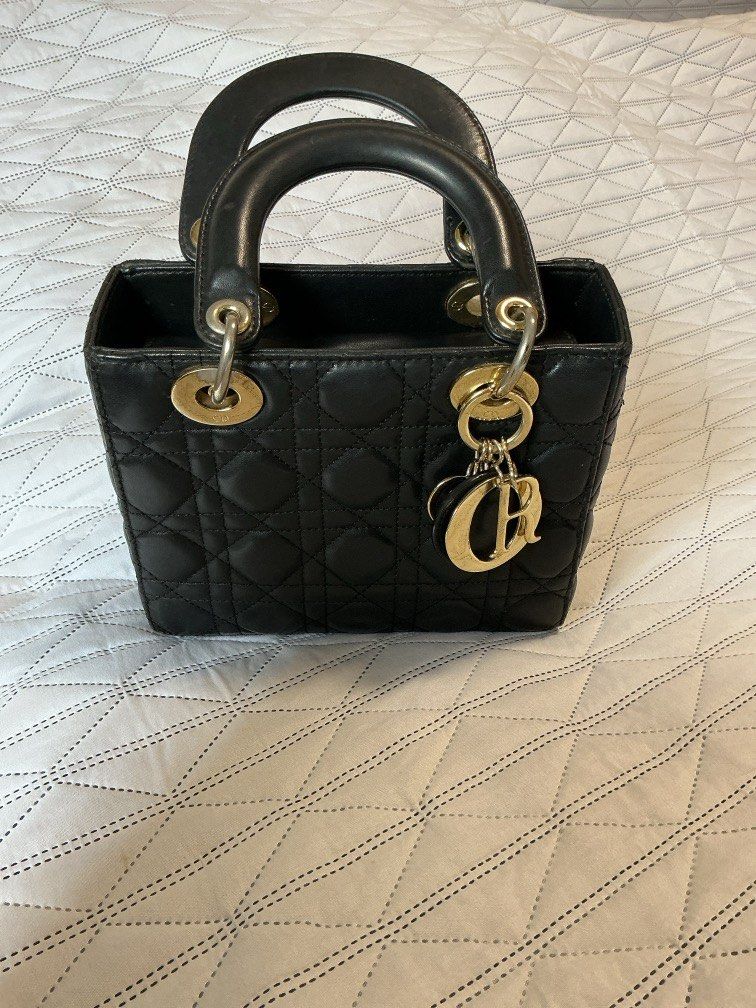 Lady Dior Bag (Category: Purses & Pouches) located in Makati City. Submitted by boldturtle-8720 (Listing ID 1459544674, Image 3). Description: Classic black lambskin Lady Dior bag accented with signature pale gold-tone hanging charms. Bag with *asterisk is the one for sale. Left bag (authentic) is for comparison only. ‘OG’ quality Includes box and dust bag. Negotiable. .