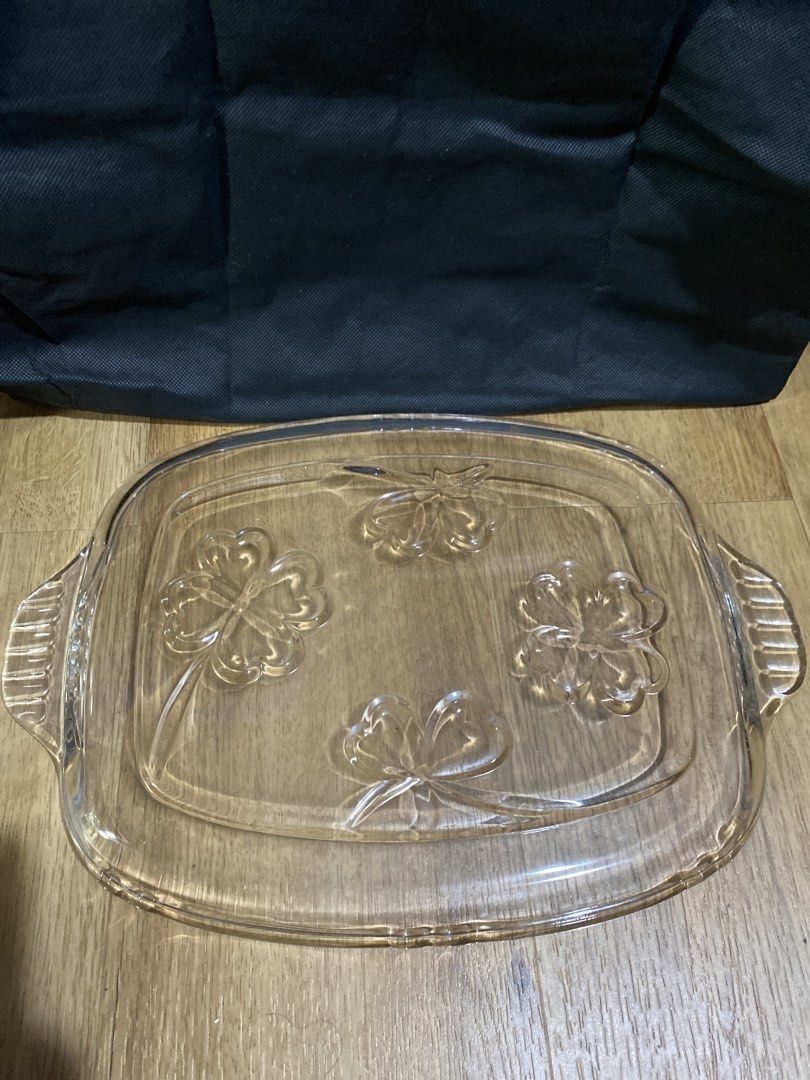 Clear Glass Serving Platter with Embossed Clover Design (Category: Dinnerware & Cutlery) located in Taguig. Submitted by cosmickindle (Listing ID 1459570879, Image 2). Description: - Rectangular glass platter - Features handles on both sides for easy carrying - Four embossed clover designs on the surface - Ideal for serving snacks or desserts - Approximate dimensions: 12 inches long x 8 inches wide - Slightly negotiable - RFS: Not in use **First 