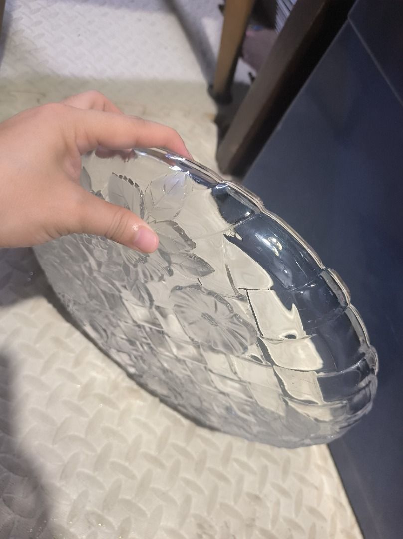 Clear Glass Serving Tray with Floral Embossing (Category: Other Kitchenware & Tableware) located in Manila. Submitted by silent_vonachiles (Listing ID 1459553679, Image 3). Description: - Elegant round glass serving tray, approximately 12 inches in diameter. - Features a unique woven basket pattern. - Adorned with embossed flowers and leaves for a decorative touch. - Scalloped edges add a charming, sophisticated detail. - Ideal for serving snacks