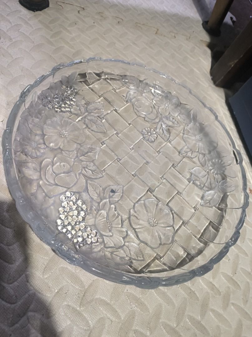 Clear Glass Serving Tray with Floral Embossing (Category: Other Kitchenware & Tableware) located in Manila. Submitted by silent_vonachiles (Listing ID 1459553679, Image 1). Description: - Elegant round glass serving tray, approximately 12 inches in diameter. - Features a unique woven basket pattern. - Adorned with embossed flowers and leaves for a decorative touch. - Scalloped edges add a charming, sophisticated detail. - Ideal for serving snacks