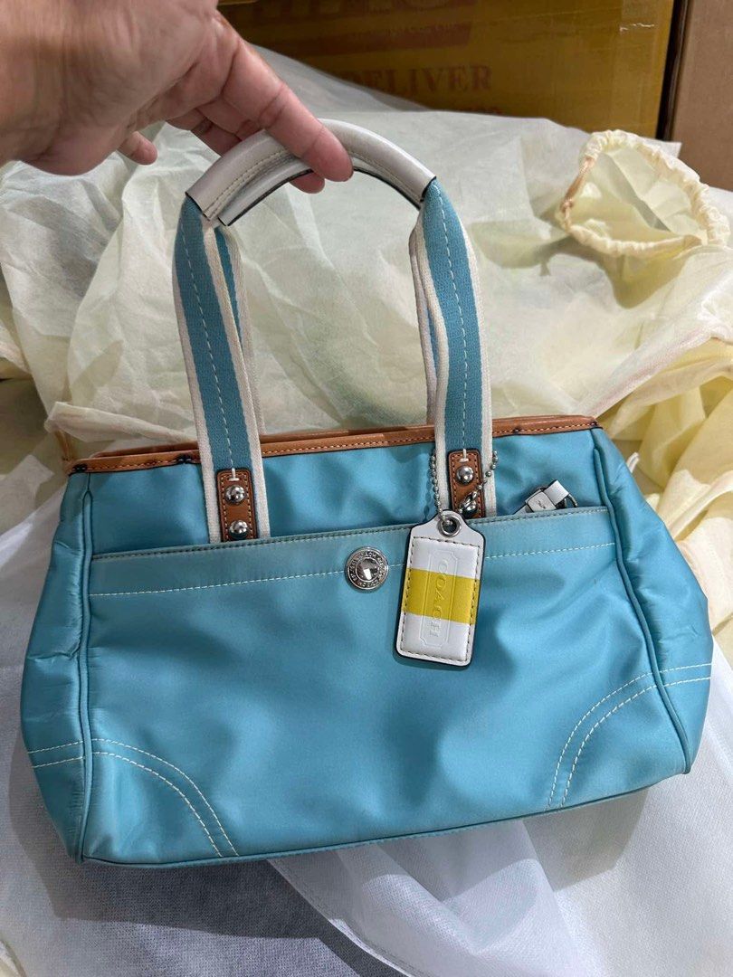 Coach Light Blue Nylon Leather Trim Tote Bag (Category: Luxury Bags & Wallets) located in Batangas. Submitted by prelove.kk (Listing ID 1459602456, Image 1). Description: - Light blue Coach tote bag - Durable nylon material with leather trim - White and blue striped straps - Comfortable white leather handles - Convenient front pocket - Authentic Coach hang tag - Ideal for everyday use.