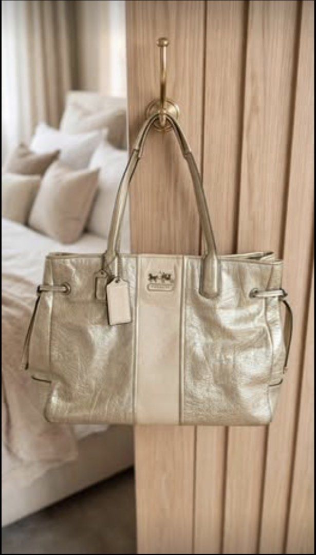 Coach Metallic Gold Leather Tote Bag (Category: Luxury Bags & Wallets) located in Lipa City. Submitted by sweetnothingsmd (Listing ID 1453616197, Image 2). Description: - Stunning metallic gold Coach tote bag - Elegant cream-colored stripe down the middle - Stylish drawstring details on the sides - Comes with two authentic Coach hang tags - Versatile for everyday use or evening events *** I've reached my REPLY QUOTA, that's why I cannot answer yo