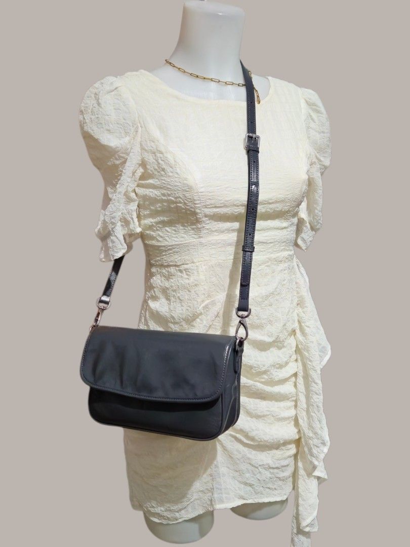 Dark Grey Leather Crossbody Shoulder Bag (Category: Cross-body Bags) located in Quezon City. Submitted by kirstenbella (Listing ID 1459548541, Image 3). Description: Dark grey leather crossbody bag - Made of pure genuine leather - Shinny texture - Zip pocket on the back - Adjustable strap with buckle - Silver hardware - Can be worn on shoulder or crossbody - Dimensions H 6.5" x L 10" x D 2.5" - Spacious compartment with inner pockets - NO Issue a