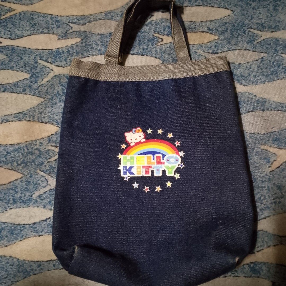 Denim Hello Kitty Tote Bag (Category: Tote Bags) located in Antipolo. Submitted by jomavi20 (Listing ID 1459637587, Image 2). Description: - Cute denim tote bag featuring Kitty graphics and positive quotes. - Perfect for everyday use or carrying your essentials. - Features two comfortable handles. - Spacious interior for ample storage. - Shows some signs of wear, but still in good usable condition. - A must-have for any Kitty enthusiast! -origina