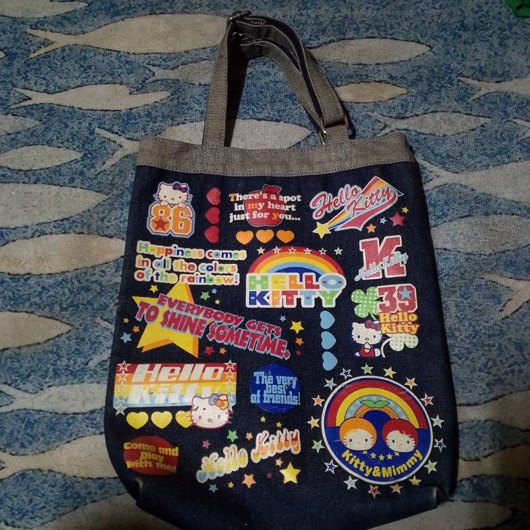 Denim Hello Kitty Tote Bag (Category: Tote Bags) located in Antipolo. Submitted by jomavi20 (Listing ID 1459637587, Image 1). Description: - Cute denim tote bag featuring Kitty graphics and positive quotes. - Perfect for everyday use or carrying your essentials. - Features two comfortable handles. - Spacious interior for ample storage. - Shows some signs of wear, but still in good usable condition. - A must-have for any Kitty enthusiast! -origina