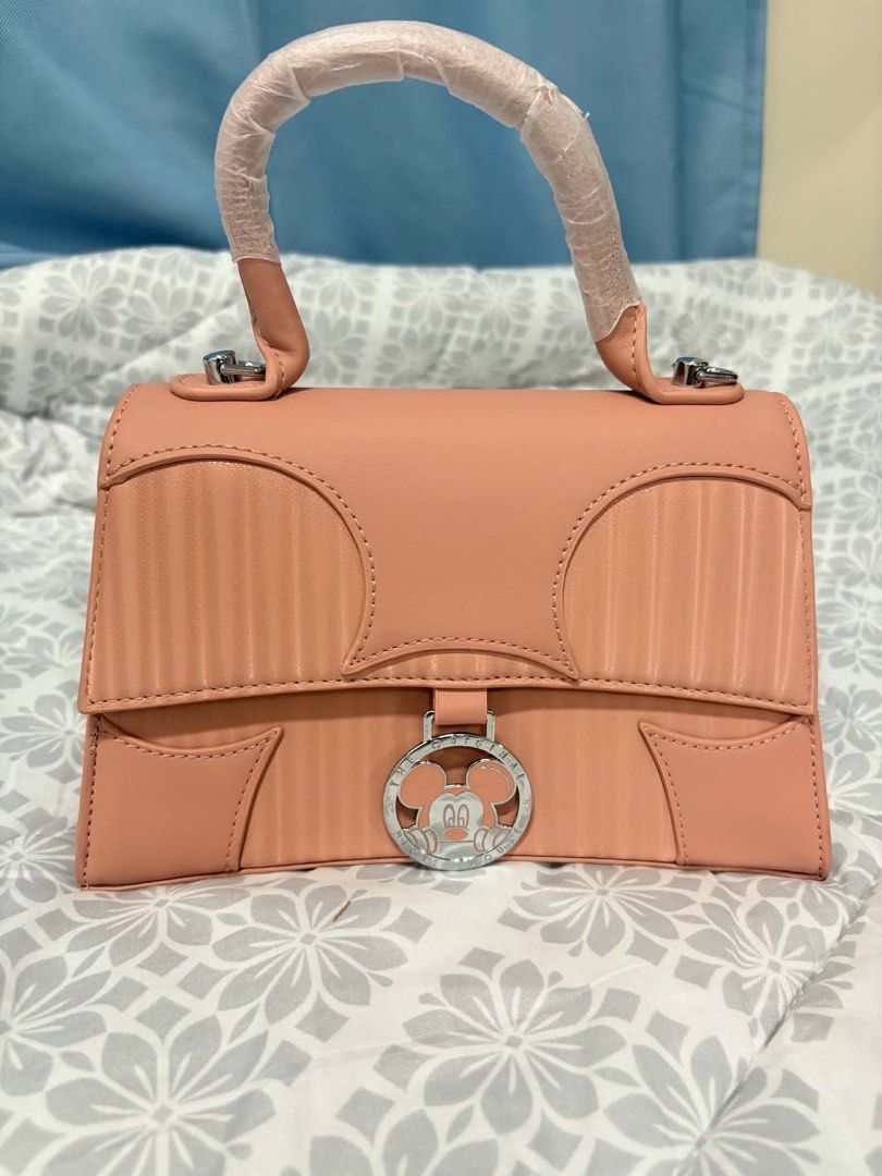 Disney Mickey Mouse Pink Top Handle Bag (Category: Shoulder Bags) located in Manila. Submitted by vengonflo (Listing ID 1459542959, Image 1). Description: - Adorable pink Disney handbag - Original Disney Bag - Features a charming Mickey Mouse clasp - Subtle Disney logo on the back - Interior zippered pocket for essentials - Handle still has protective plastic wrap - A must-have for any Disney enthusiast!.