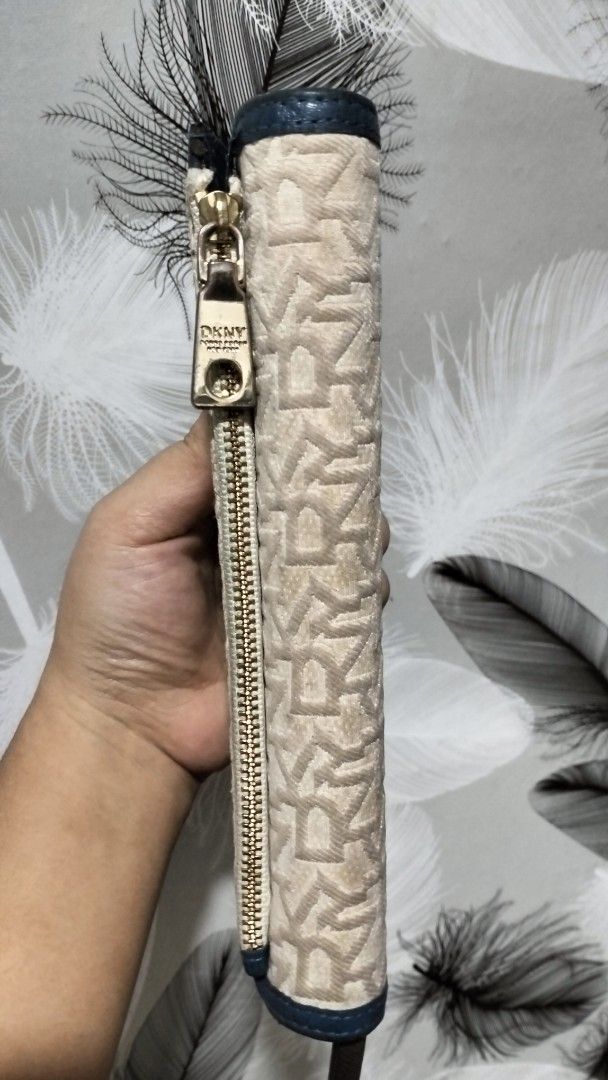 DKNY Monogram Long Wallet (Category: Wallets & Card holders) located in Quezon City. Submitted by borresashl49573 (Listing ID 1459674480, Image 3). Description: - DKNY long wallet embossed 😍 - Signature monogram pattern ♥️ - Color: Beige and Navy Blue - Closure: Zip around - Interior: Multiple card slots and compartments - Hardware: Gold tone - Condition: Very good condition, need lang ng linis to 😊.