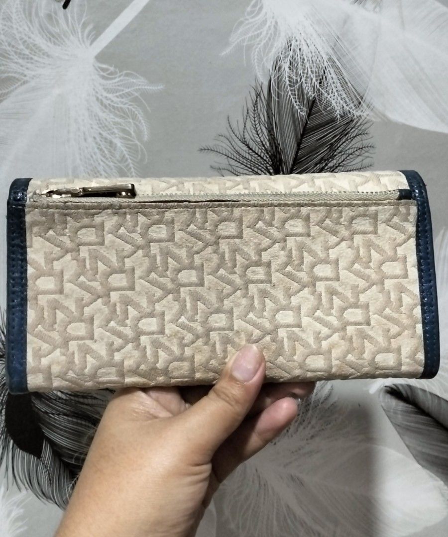 DKNY Monogram Long Wallet (Category: Wallets & Card holders) located in Quezon City. Submitted by borresashl49573 (Listing ID 1459674480, Image 2). Description: - DKNY long wallet embossed 😍 - Signature monogram pattern ♥️ - Color: Beige and Navy Blue - Closure: Zip around - Interior: Multiple card slots and compartments - Hardware: Gold tone - Condition: Very good condition, need lang ng linis to 😊.