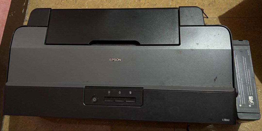 Epson L1300 A3+ Printer (Category: Printers, Scanners & Copiers) located in Manila. Submitted by mstues (Listing ID 1459599969, Image 1). Description: - Epson L1300 Printer - A3 print size capability - Ideal for large documents, graphics, and photos - Includes original box - Need lang ink cleaning/flushing since matagal di nagamit but still working.