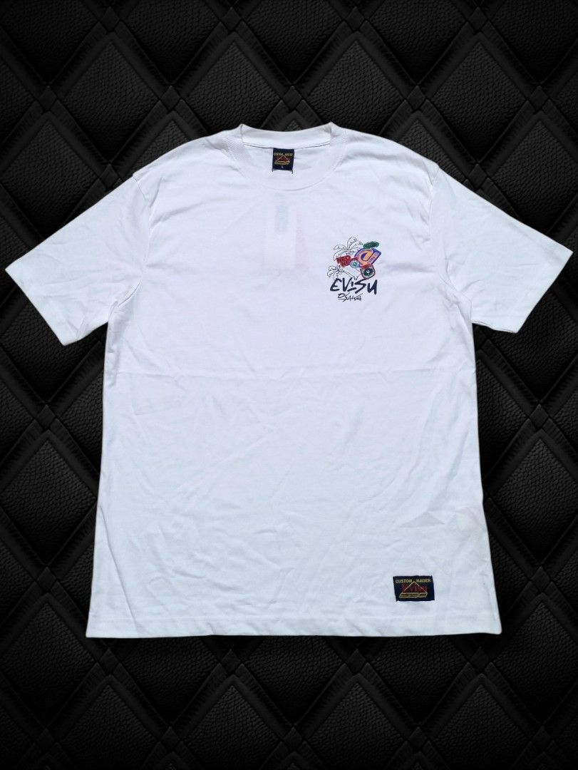 EVISU White Graphic Print T-Shirt I Tee (Category: Tshirts & Polo Shirts ) located in Aguinaldo. Submitted by baguioukayukay2600 (Listing ID 1459515332, Image 2). Description: - White Evisu t-shirt - Features a cool graphic print on the back - Includes Evisu branding and colorful patches - Short sleeves and crew neck design - Ideal for casual wear.