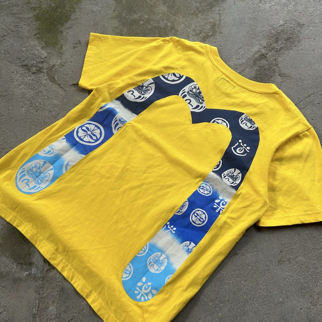EVISU Yellow Graphic T-Shirt (Category: Tshirts & Polo Shirts ) located in Manila. Submitted by thriftified.dept (Listing ID 1459584060, Image 2). Description: EVISU DAICOCK TEE Size: Fit to Small (Small on tag) Length: 25” | Width: 20” Condition: 10/10 Color rate: 10/10 Good as new.