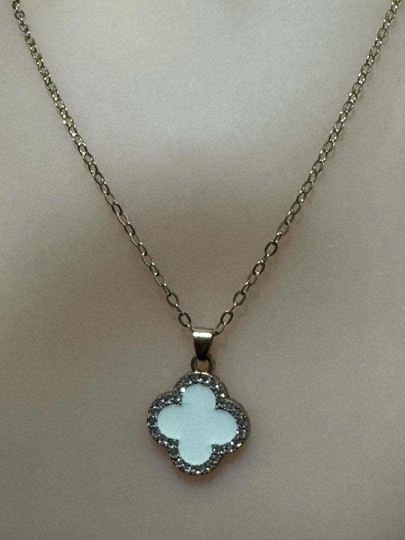 four-leaf clover pendant necklace (Category: Necklaces) located in Angeles City. Submitted by zyeplustradings (Listing ID 1459526977, Image 1). Description: four-leaf clover pendant necklace The piece features a delicate gold-toned chain holding a prominent quatrefoil (clover) pendant. The center of the clover is inlaid with a smooth, iridescent white mother-of-pearl material, framed beautifully by a border of shimmering, pave-set cubic zirconia 
