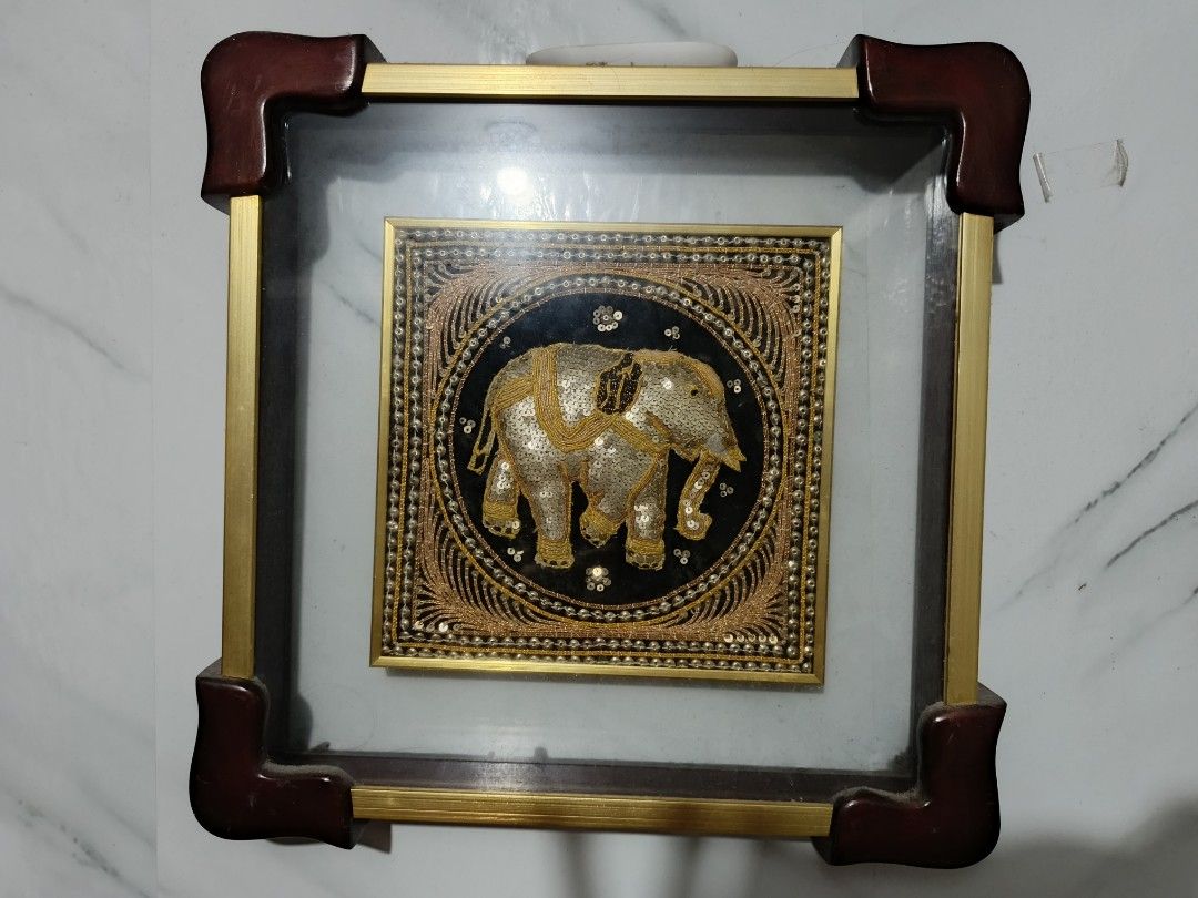 Framed Elephant Wall Art - Gold and Black (Category: Frames & Pictures) located in San Pedro. Submitted by kanor1234 (Listing ID 1459636301, Image 1). Description: - Beautiful framed artwork with a detailed elephant design. - Intricate embroidery using gold thread and sequins. - Set against a striking black background. - Housed in a square frame with elegant gold metal accents. - Dark brown corner protectors for added detail. - A unique and eye-c