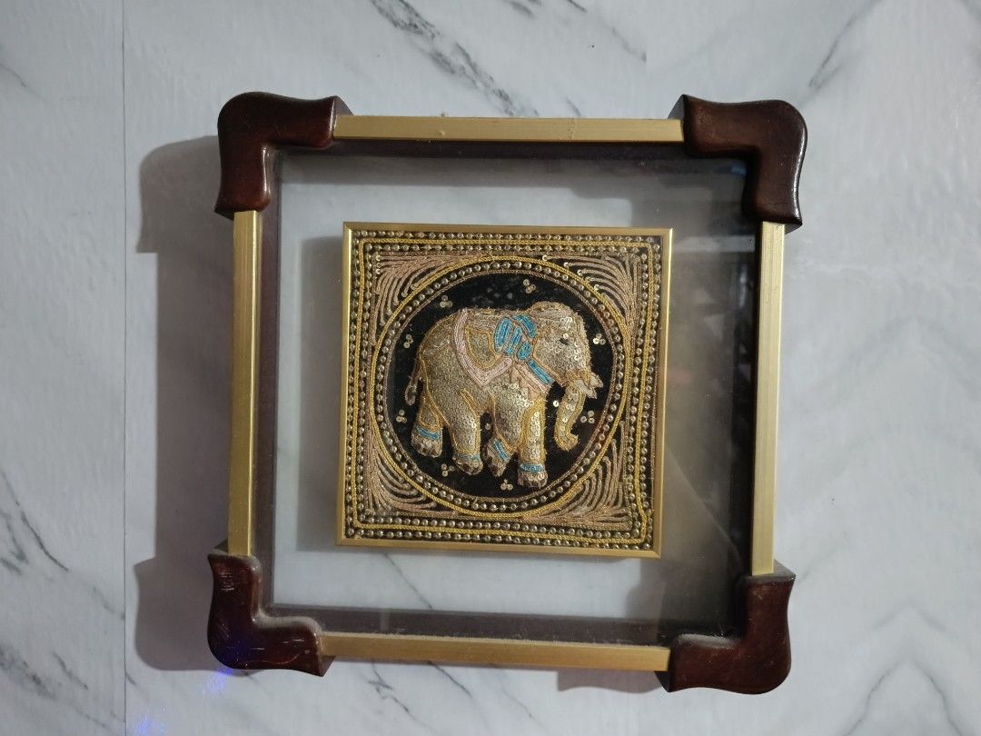 Framed Elephant Wall Art - Gold and Black (Category: Frames & Pictures) located in San Pedro. Submitted by kanor1234 (Listing ID 1459636301, Image 3). Description: - Beautiful framed artwork with a detailed elephant design. - Intricate embroidery using gold thread and sequins. - Set against a striking black background. - Housed in a square frame with elegant gold metal accents. - Dark brown corner protectors for added detail. - A unique and eye-c