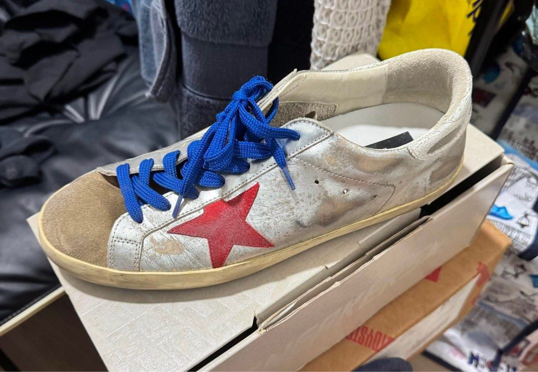 Golden Goose Super-star (Category: Sneakers) located in Manila. Submitted by martin827 (Listing ID 1459523875, Image 1). Description: Silver crackled/laminated leather upper, red signature leather star applique, blue laces, suede toe box, and the brand’s iconic pre-distressed/worn finish.