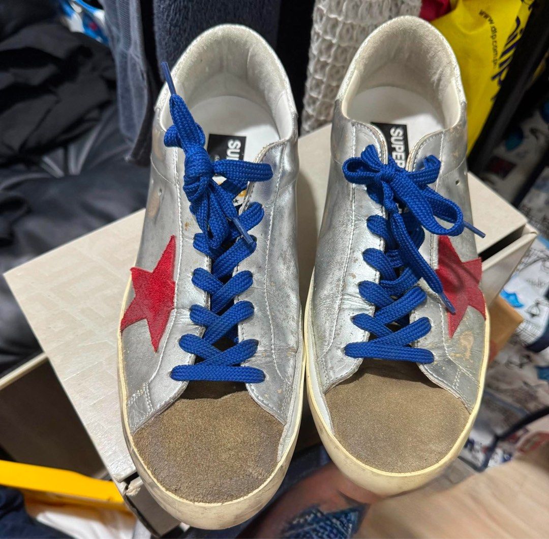 Golden Goose Super-star (Category: Sneakers) located in Manila. Submitted by martin827 (Listing ID 1459523875, Image 2). Description: Silver crackled/laminated leather upper, red signature leather star applique, blue laces, suede toe box, and the brand’s iconic pre-distressed/worn finish.