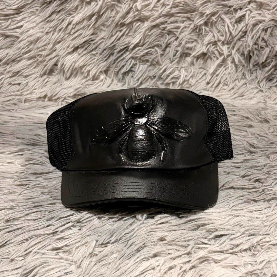 Gucci Black Leather Bee Trucker Cap (Category: Caps & Hats) located in Santa Rosa. Submitted by klarksantos (Listing ID 1459600845, Image 3). Description: - Authentic Gucci trucker cap - Iconic bee emblem on the front - Leather front panel - Breathable mesh back - Adjustable strap for a custom fit - Versatile accessory for any outfit.