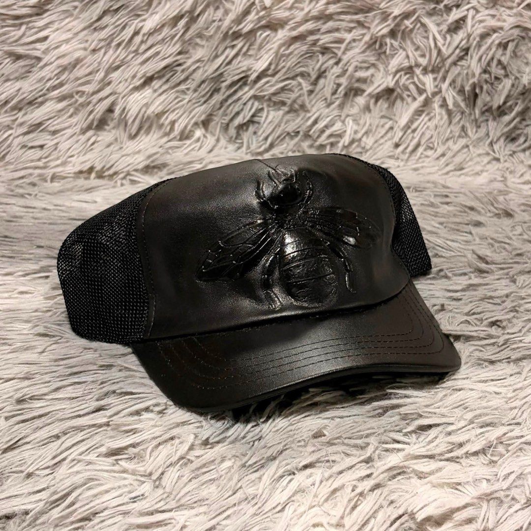 Gucci Black Leather Bee Trucker Cap (Category: Caps & Hats) located in Santa Rosa. Submitted by klarksantos (Listing ID 1459600845, Image 2). Description: - Authentic Gucci trucker cap - Iconic bee emblem on the front - Leather front panel - Breathable mesh back - Adjustable strap for a custom fit - Versatile accessory for any outfit.