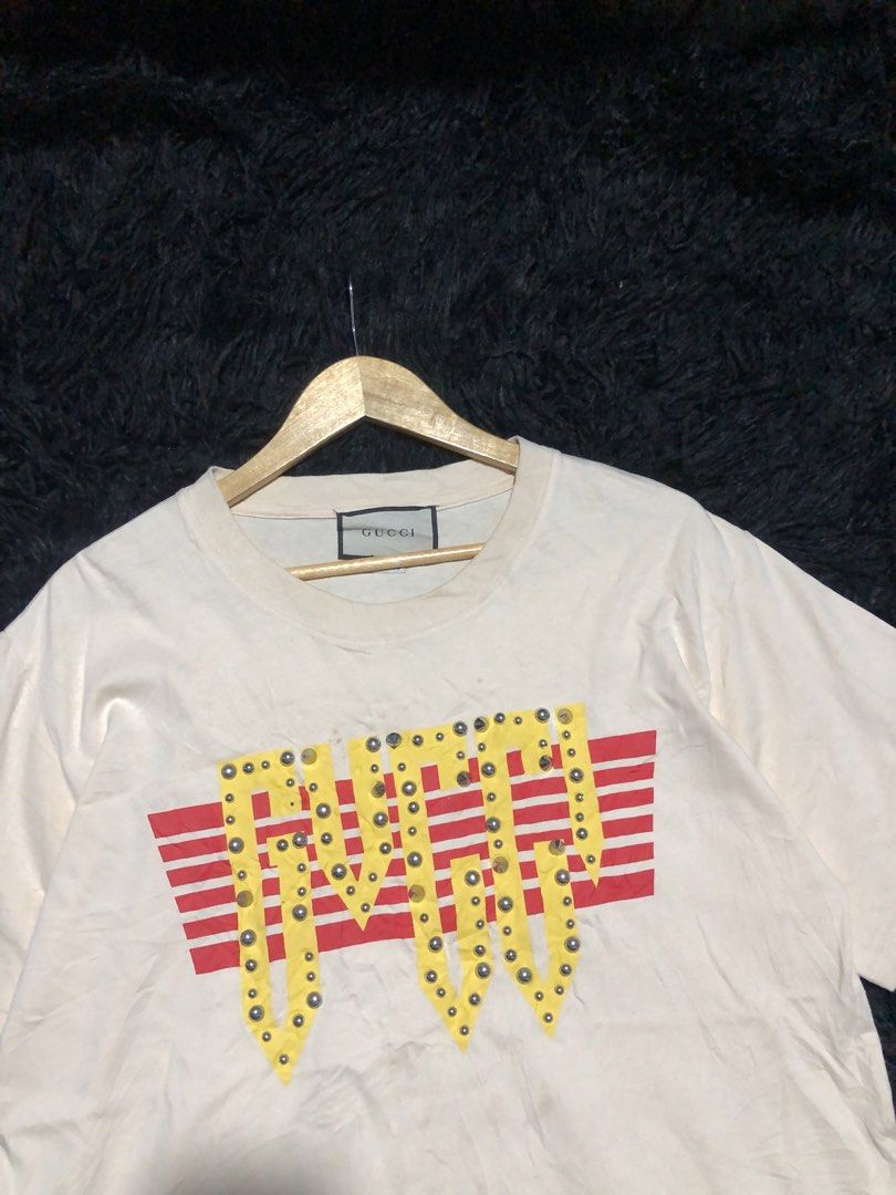 Gucci T-shirt k (Category: Tshirts & Polo Shirts ) located in Munoz. Submitted by bb_jimbo0 (Listing ID 1459614840, Image 2). Description: - Cream colored Gucci T-shirt - Size 3XL - Features a red and yellow graphic with studs - Made in Italy - Minor marks present (please check photos for details).