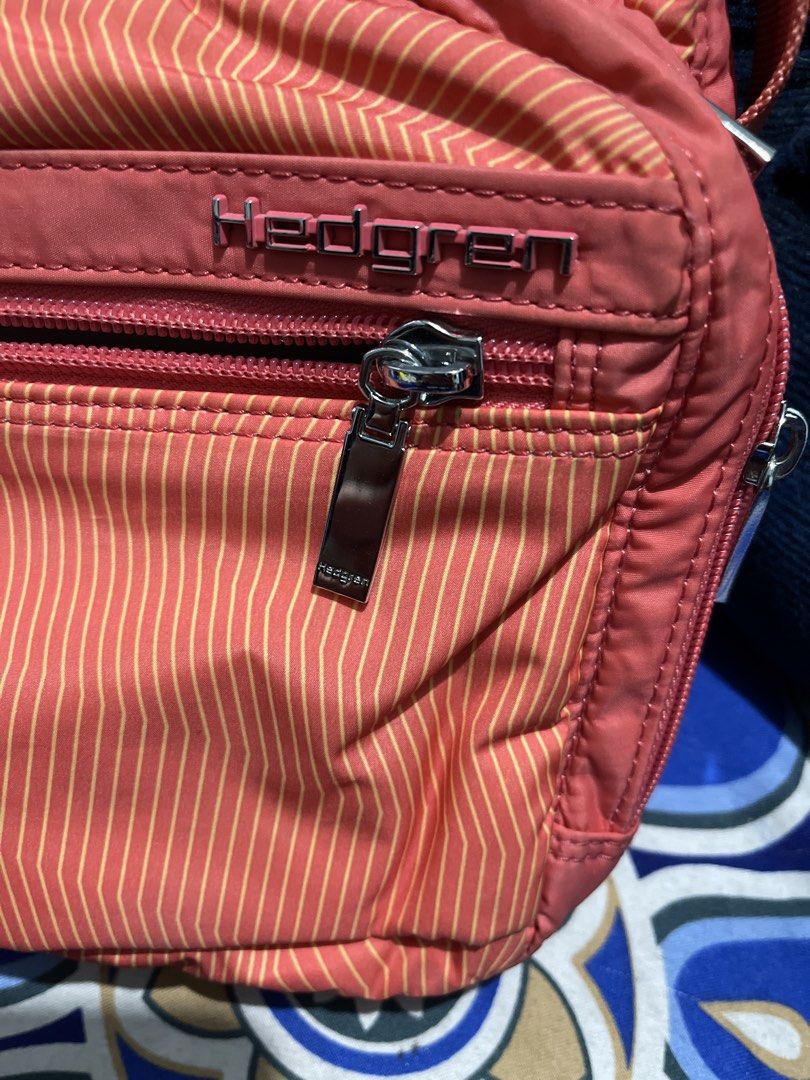 Hedgren Coral Striped Crossbody Bag (Category: Cross-body Bags) located in Manila. Submitted by edensy (Listing ID 1459639725, Image 2). Description: - Coral pink Hedgren crossbody bag - Subtle stripe pattern and need washing due to stock in cabinet - Multiple zippered compartments for organization - Adjustable strap - Silver hardware details - Great for everyday use.