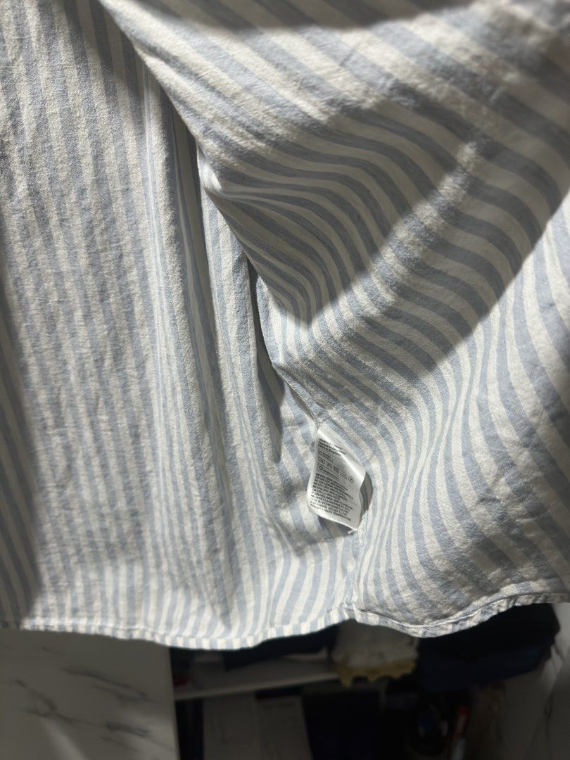 H&M Slim Fit Striped Button-Up Shirt (Category: Tshirts & Polo Shirts ) located in Baguio. Submitted by miss_misery (Listing ID 1459641504, Image 3). Description: - H&M Slim Fit Shirt - Color: Light blue and white vertical stripes - Style: Button-up front with collar - Sleeves: Long sleeves - Occasion: Perfect for casual wear or dressing up - Sizing: Please refer to the tag for specific size details.