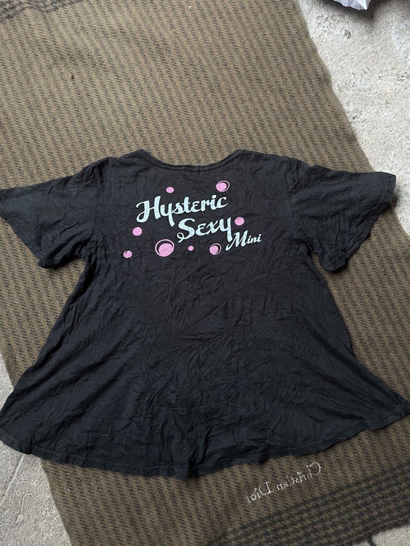 Hysteric Glamour Graphic Print (Category: Shirts) located in Siniloan. Submitted by rethr1ft (Listing ID 1459609395, Image 2). Description: - Brand: Hysteric Glamour Mini - Design: Black graphic tee - Front: Features a cute cartoon character - Back: 'Hysteric Sexy Mini' text - Sleeves: Short - Hem: Flared - Style: Casual wear.