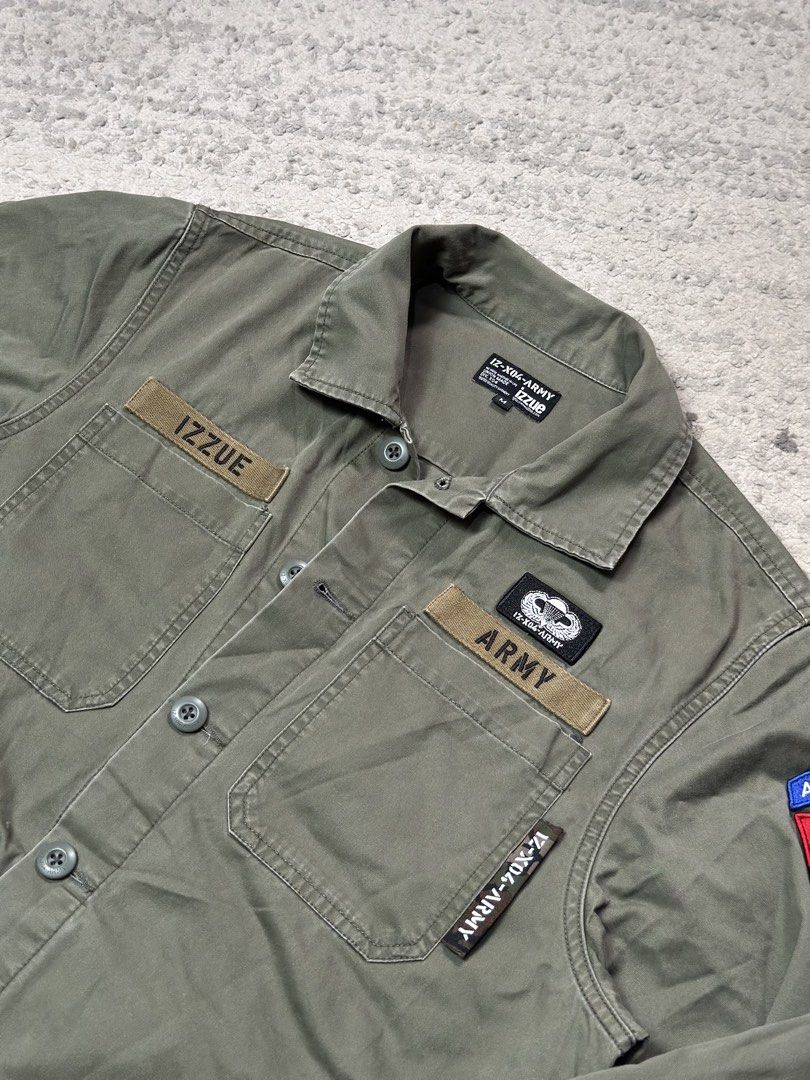 IZZUUE Army Division-04 Utility Button-Down Jacket (Category: Coats, Jackets and Outerwear) located in Daet. Submitted by thrifthings2018 (Listing ID 1459577834, Image 3). Description: IZZUUE Army Division-04 utility jacket. Military-style button-down. Olive green color. Features patches and embroidery. Width 23, length 28. Excellent condition. Great for casual wear..