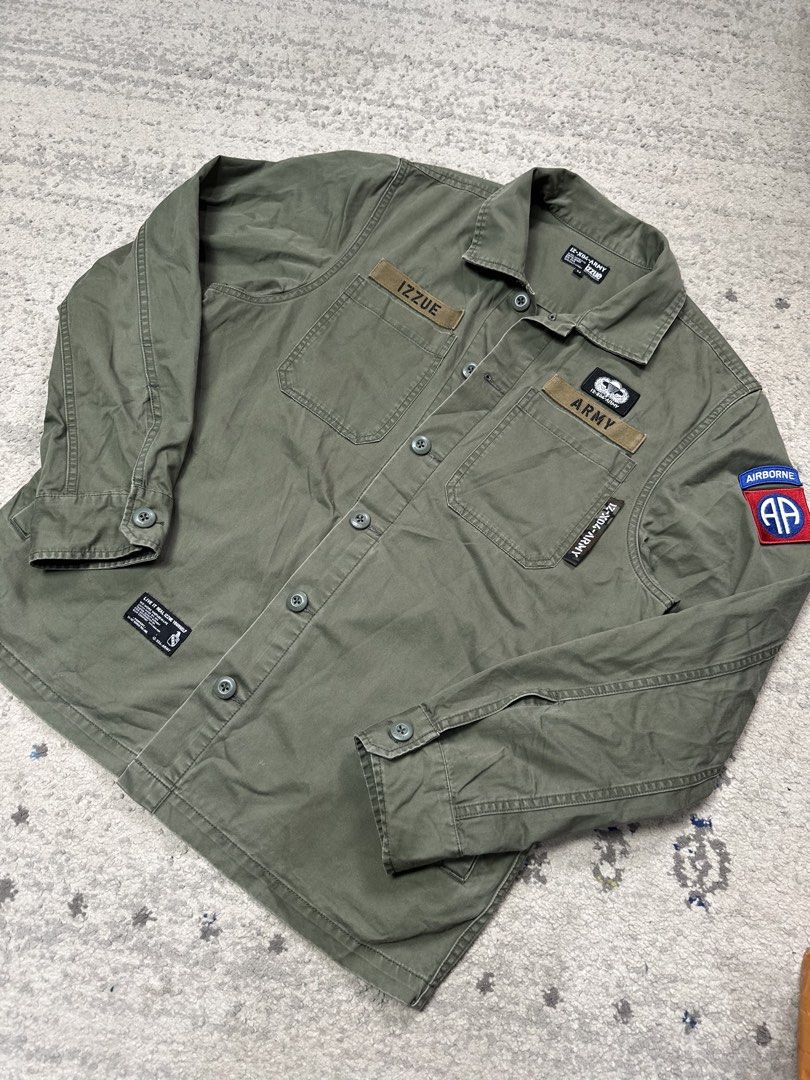 IZZUUE Army Division-04 Utility Button-Down Jacket (Category: Coats, Jackets and Outerwear) located in Daet. Submitted by thrifthings2018 (Listing ID 1459577834, Image 2). Description: IZZUUE Army Division-04 utility jacket. Military-style button-down. Olive green color. Features patches and embroidery. Width 23, length 28. Excellent condition. Great for casual wear..
