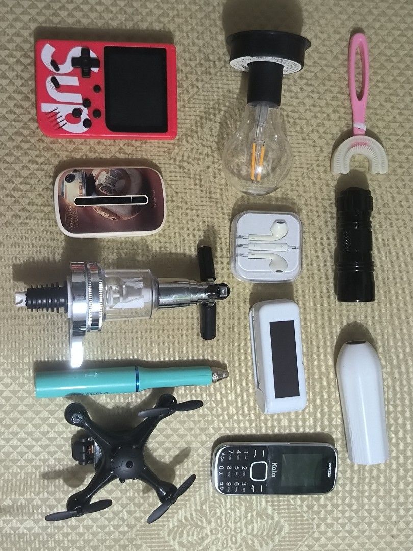 Jackpot Bundle K8 (Category: Everything Else Others) located in Quezon City. Submitted by jhiim (Listing ID 1459594816, Image 1). Description: As is where is, Declared as untested. - Retro-style gaming console (red) - Star Wars themed portable Wi-Fi device - Mini drone - Kata feature phone - Chrome and clear bottle dispenser - Black LED flashlight - Teal pen - Pink U-shaped toothbrush - Portable LED light bulb.