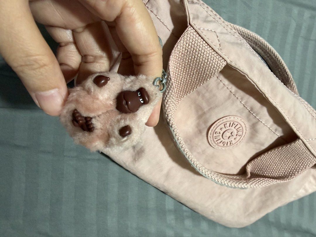 Kipling Pink Nylon Top Handle Bag with Shoulder Strap (Category: Cross-body Bags) located in Quezon City. Submitted by djmcderay (Listing ID 1459643217, Image 2). Description: - Adorable pink Kipling bag - Made from durable nylon material - Comfortable top handles - Detachable shoulder strap for versatility - Comes with the iconic fluffy monkey charm - Interior features a secure zippered pocket and a handy slip pocket - Smooth-gliding zippers - I